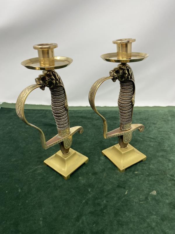 A MATCHED PAIR OF CANDLE HOLDERS MADE FROM GERMAN LIONS HEAD SWORD HILTS.