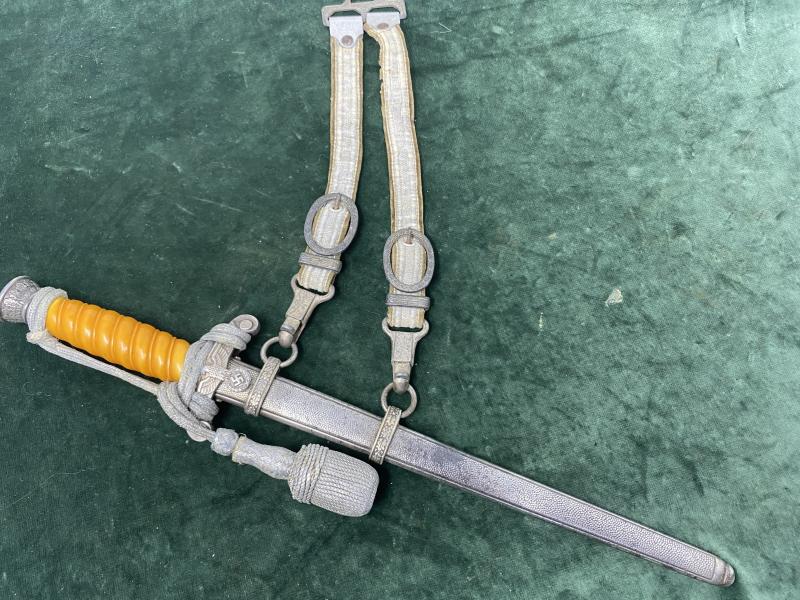 A PERSONALISED/NAMED ARMY DAGGER IDENTIFIED TO AN OFFICER BY ALCOSO WITH STRAPS AND KNOT.