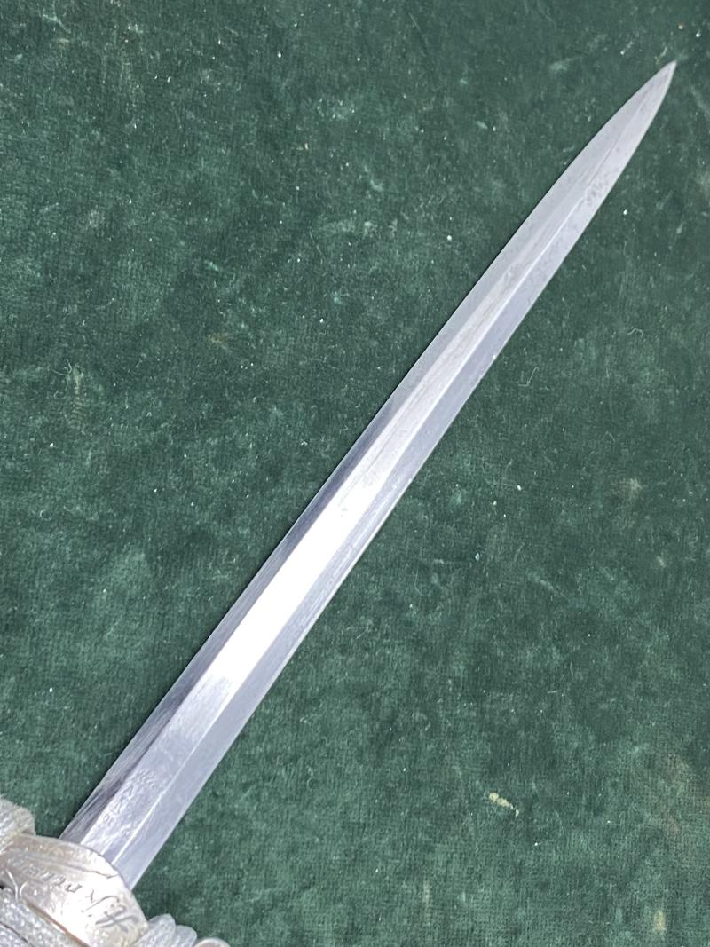 A PERSONALISED/NAMED ARMY DAGGER IDENTIFIED TO AN OFFICER BY ALCOSO WITH STRAPS AND KNOT.